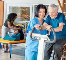 Caregiver assisting an elderly woman do exercise